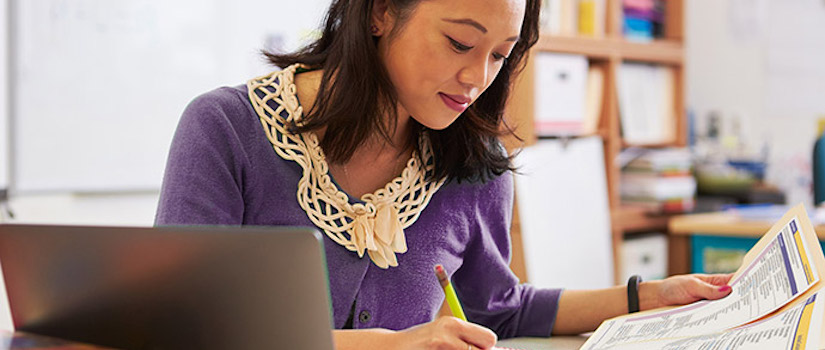 “teacher-at-desk-in-classroom“