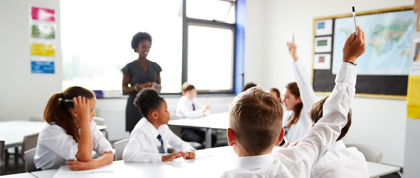 “student-raising-hand-in-classroom“